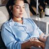 Woman relaxing during an iron infusions session while working on a laptop at Amani Health and Wellness