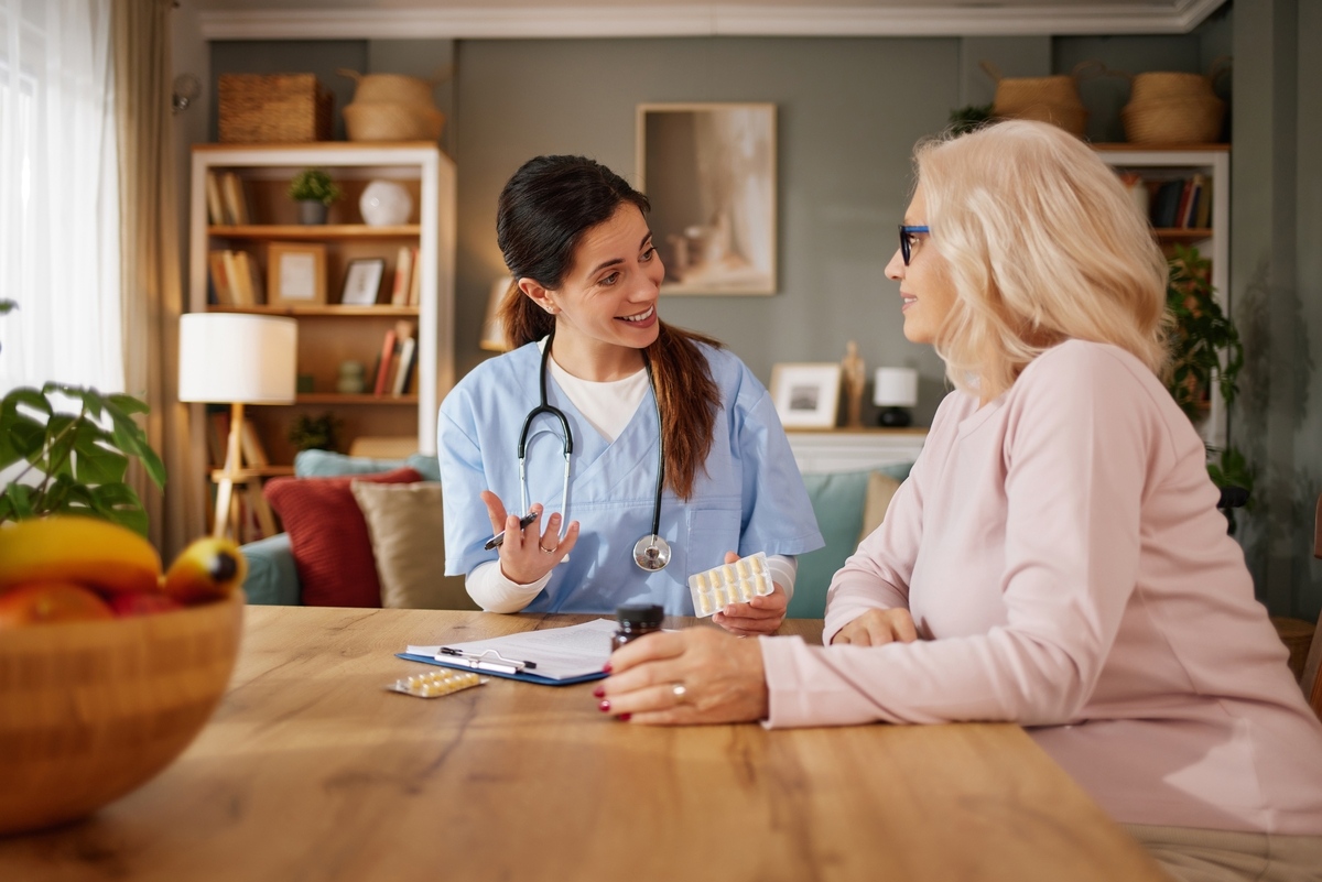 Licensed nurse reviewing medication with female patient at home during concierge nursing visit in Arlington TX