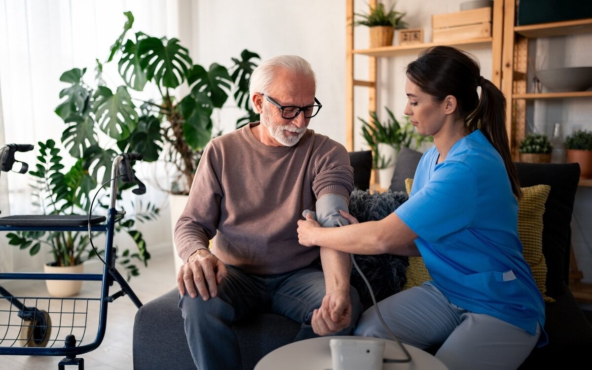 Chronic Illness Nursing Care: Nurse Checking Patient's Blood Pressure
