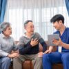Licensed concierge nurse reviewing care information with an older couple on a tablet during a home visit