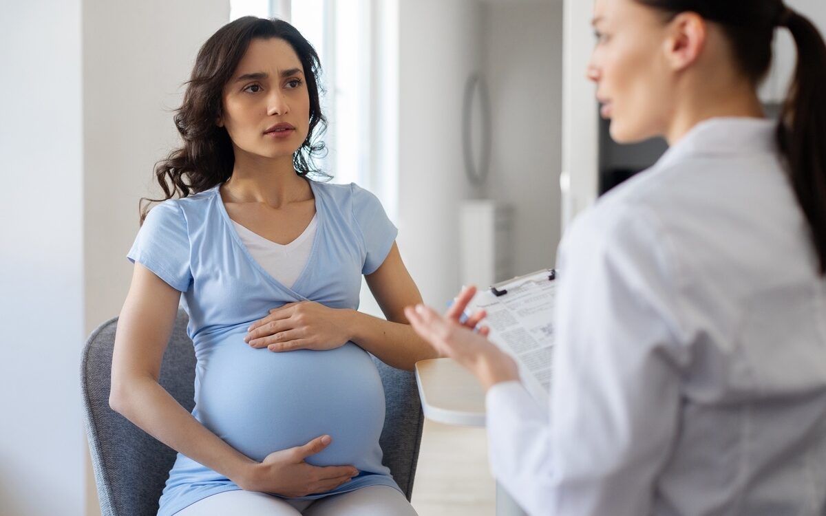 Pregnant woman discussing iron infusion during pregnancy with her provider during a consultation