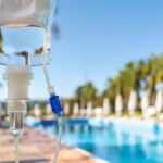 Mobile IV therapy for group events: an IV bag set up poolside at a resort-style outdoor gathering